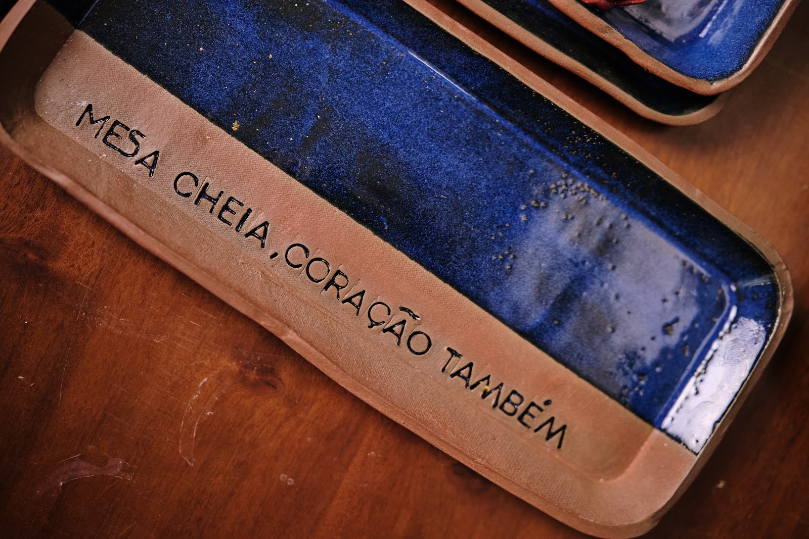 Bandeja azul com a frase gravada: mesa cheia, coração também