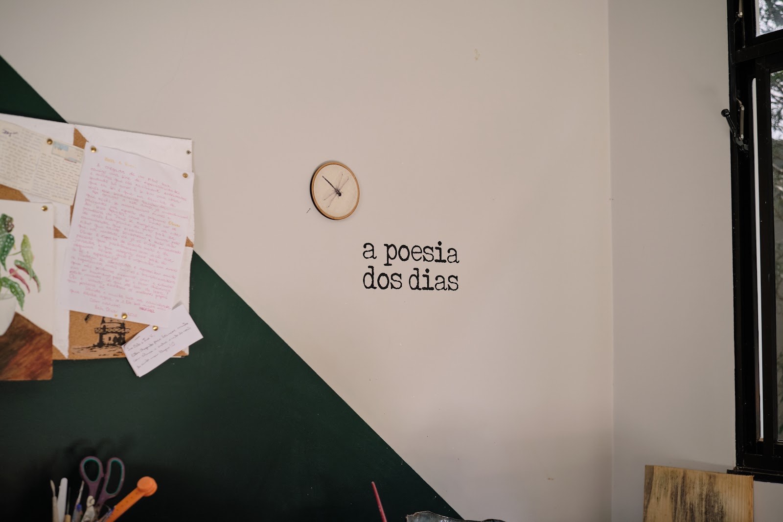 Parede do ateliê com a frase a poesia dos dias