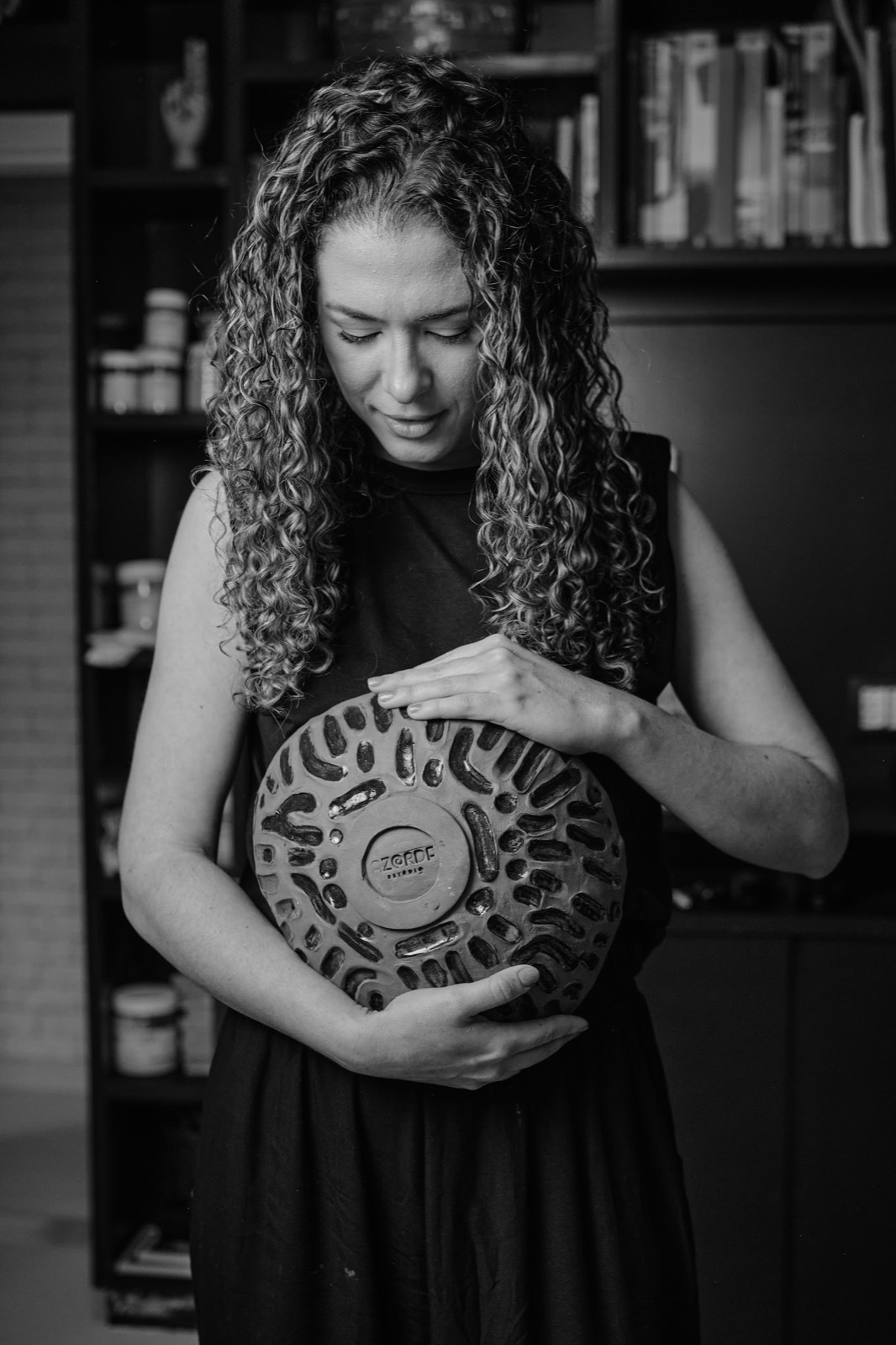 Isabela Malheiros segura uma peça de cerâmica no ateliê Azorde